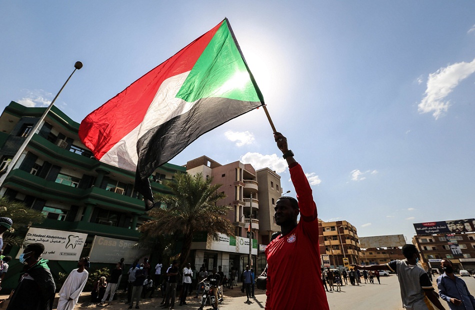 مواطن سوداني يرفع علم بلاده